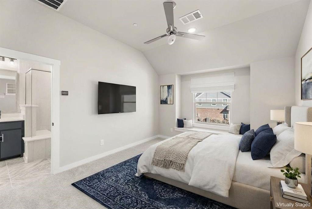 Vaulted ceiling featuring a ceiling fan, window alcove with built-in bench seating, and wall-mounted television