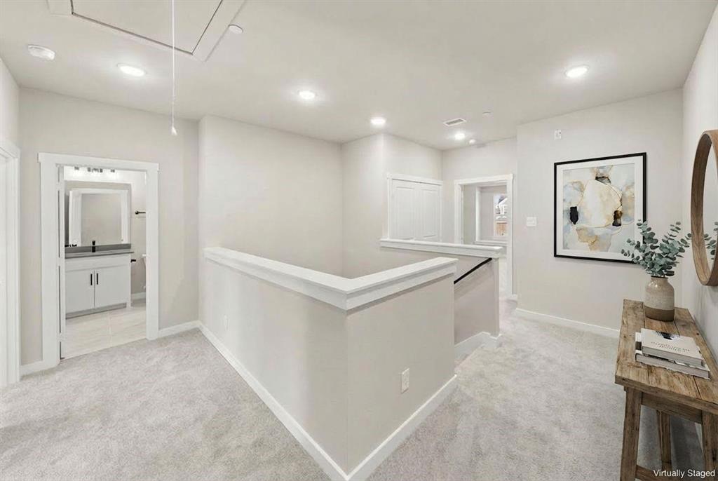 Neutral-toned carpeting, recessed lighting, and a crisp architectural half-wall