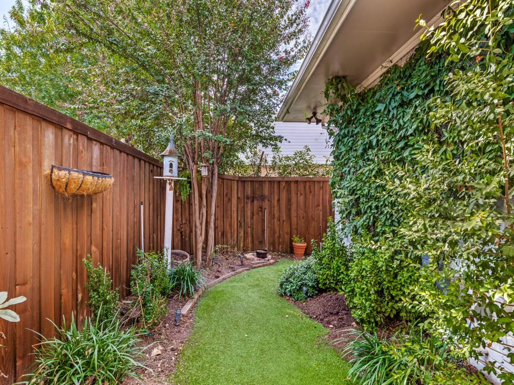 Landscaped backyard with turf tall wooden privacy fence