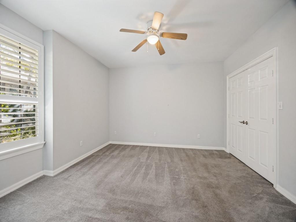 Bedroom with ceiling fan and double-door closet