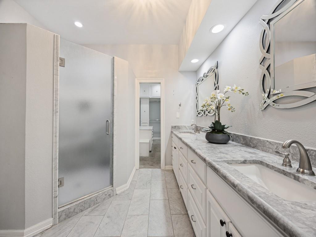 Marble-tile primary bath leads to the walk-in closet