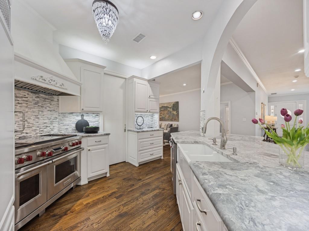 Farmhouse sink, stone counters and sightlines to the front entry and living area