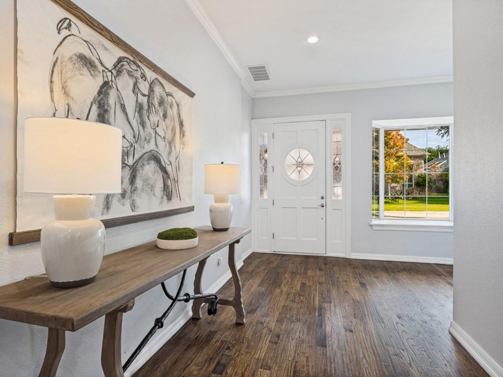 Bright foyer with rich hardwood floors and crown molding Bright foyer with rich hardwood floors and crown molding