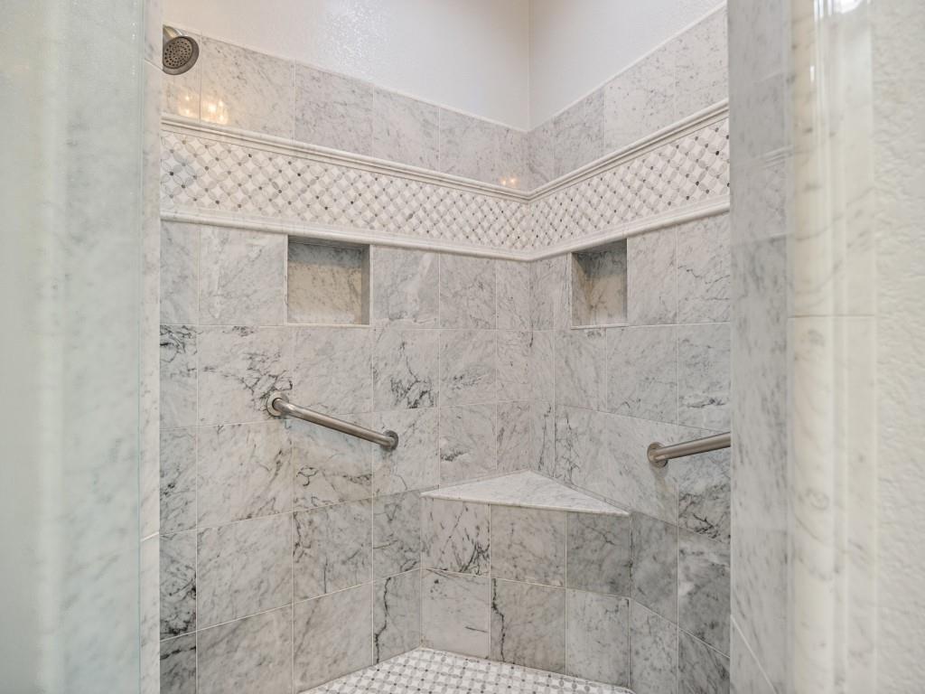 Marble walk-in shower with bench, niches and grab bars