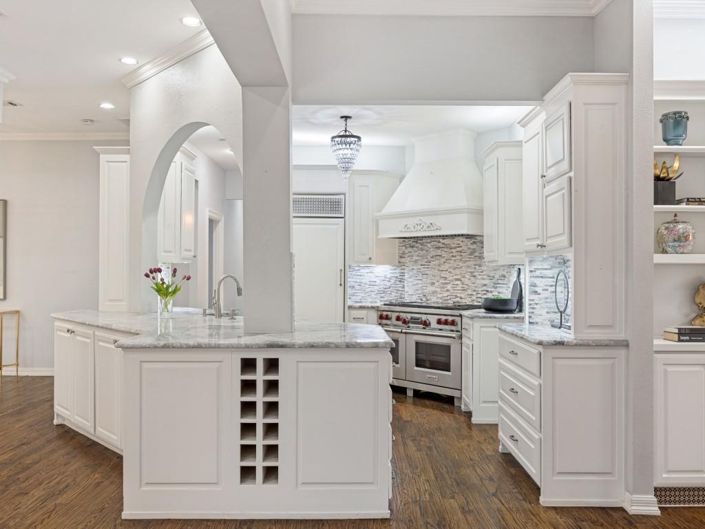 Kitchen peninsula with abundant storage opens to the den