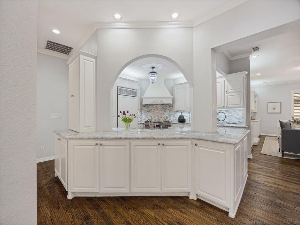 Chef’s kitchen with Wolf range, custom vent hood and mosaic backsplash Chef’s kitchen with Wolf range, custom vent hood and mosaic backsplash
