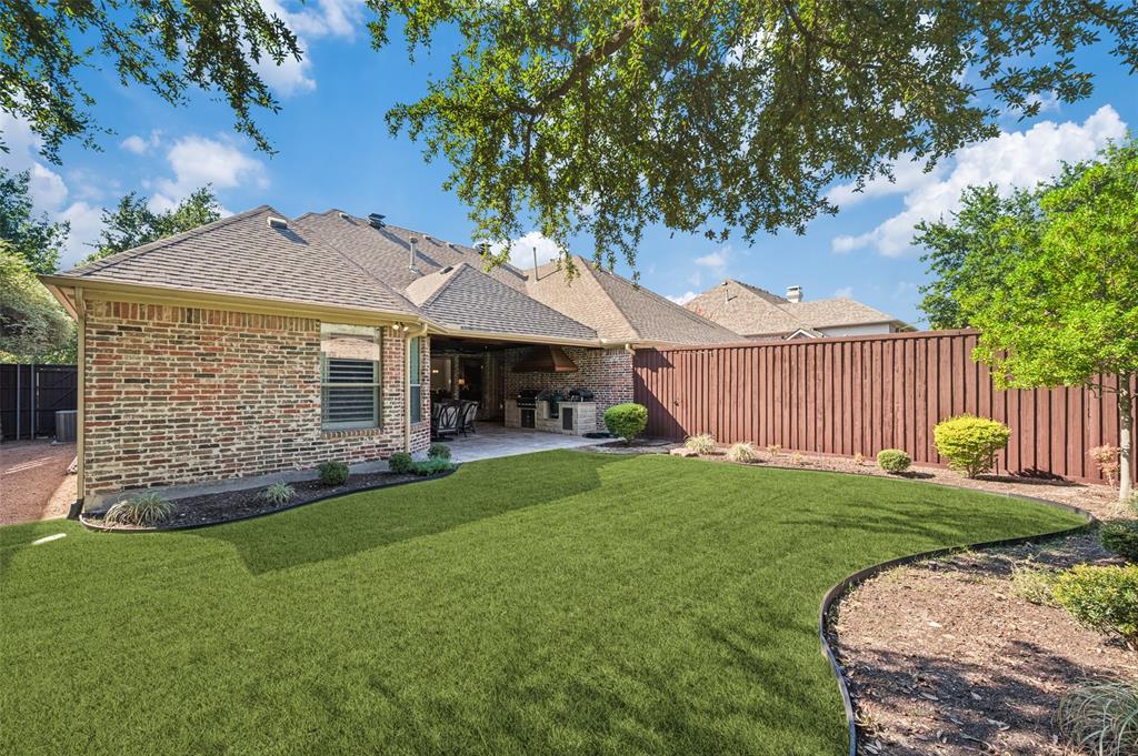 Expansive backyard featuring a manicured lawn, an extended patio, and a privacy fence