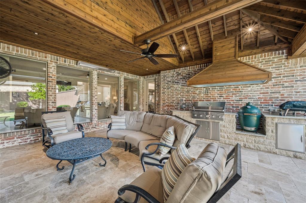 Covered outdoor patio with a wood-plank ceiling, exposed wood beams, and a ceiling fan