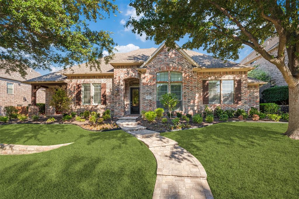 Brick exterior with stone accents, a covered entry, and a paver walkway