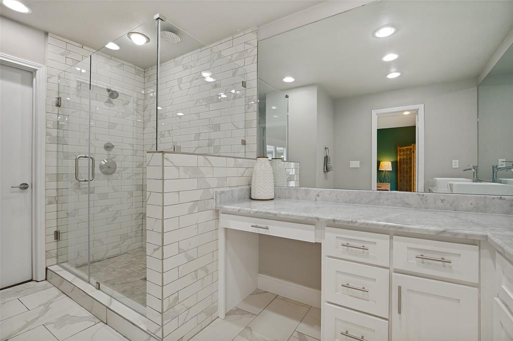 Shower featuring clear glass enclosure, subway tile surround, rain showerhead, and wall-mounted shower system