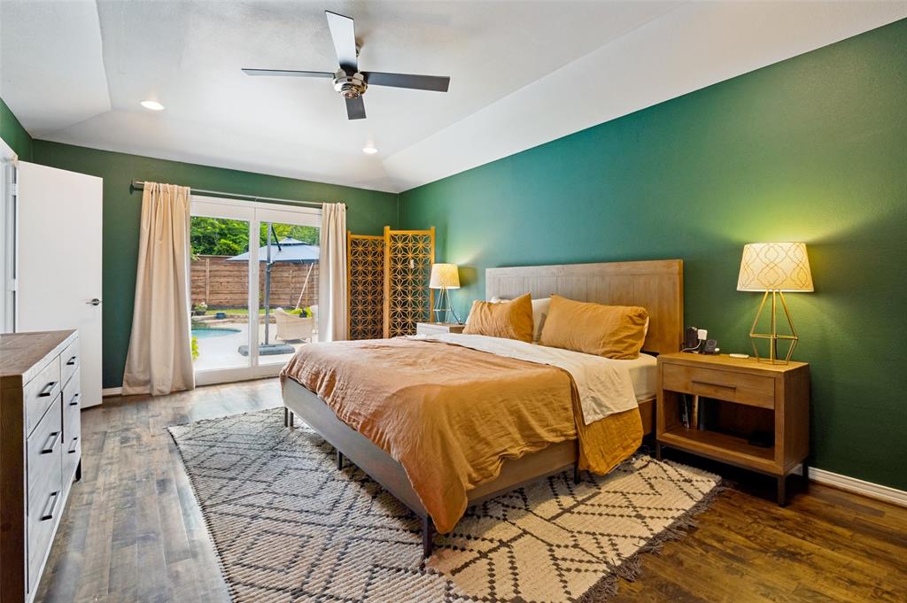 Spacious room featuring wood-finish flooring, a vaulted ceiling with recessed lighting and a ceiling fan, and direct access to the outdoor area through sliding glass doors