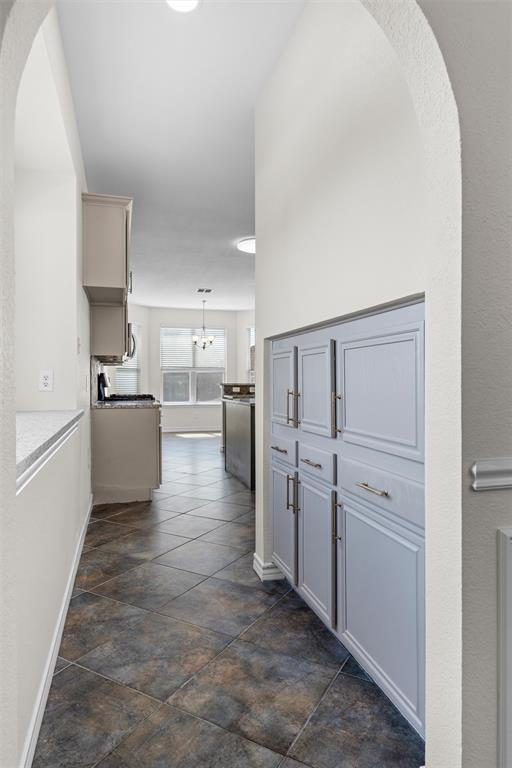 Archway entry featuring built-in cabinetry, tile flooring, and recessed lighting