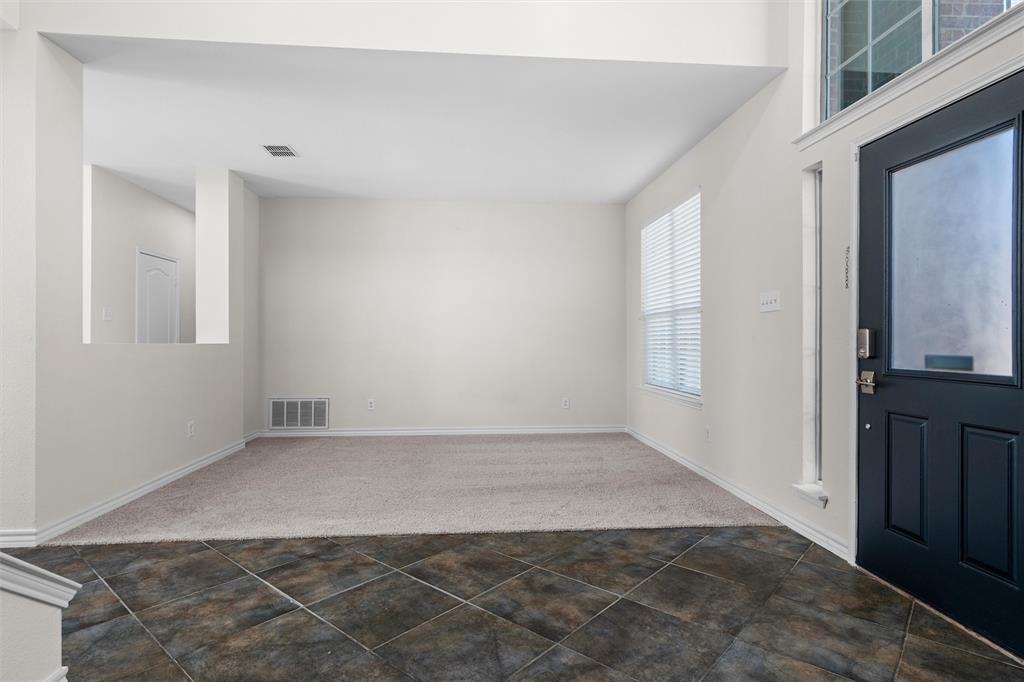 Two-story entry foyer with dark-toned tile flooring