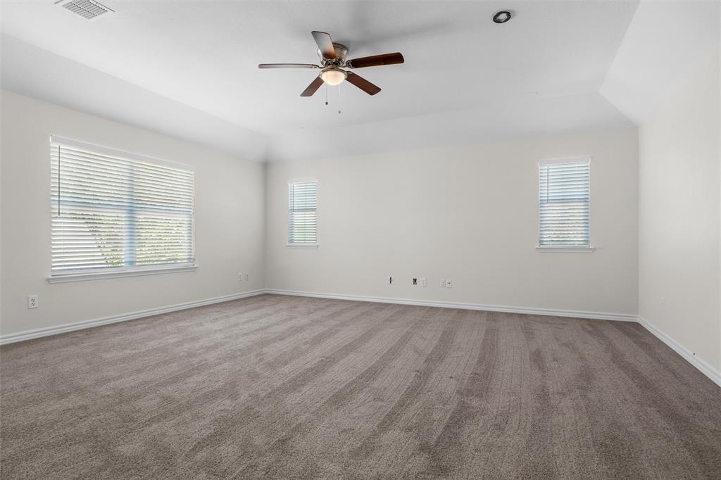 Expansive room featuring vaulted ceilings, a ceiling fan with integrated lighting, recessed lighting, two windows with blinds, and neutral carpeting