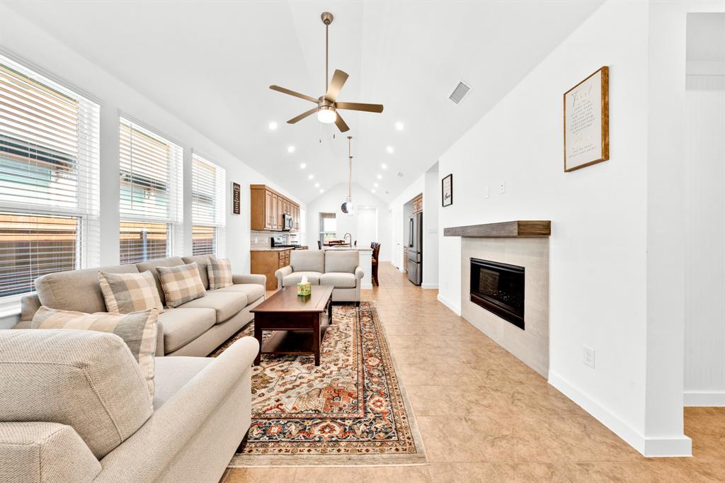 Vaulted ceilings, recessed lighting, and a ceiling fan enhance the living area