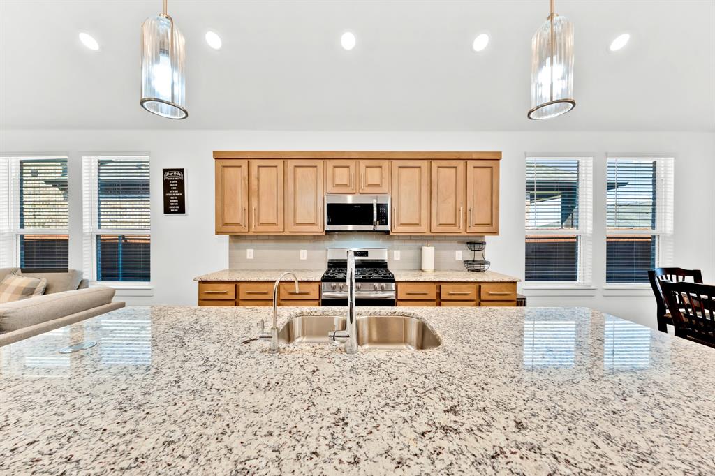 Extended kitchen island with stone countertop and undermount sink