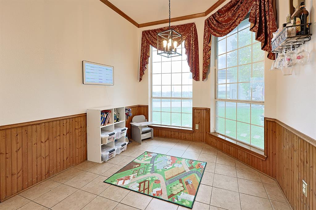 Tile flooring, wood wainscoting, floor-to-ceiling windows, and a geometric metal pendant light fixture