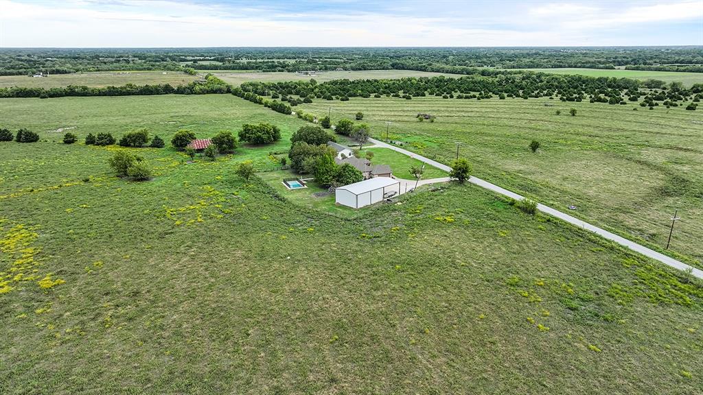 Expansive acreage featuring a private swimming pool, detached metal structure, and paved driveway