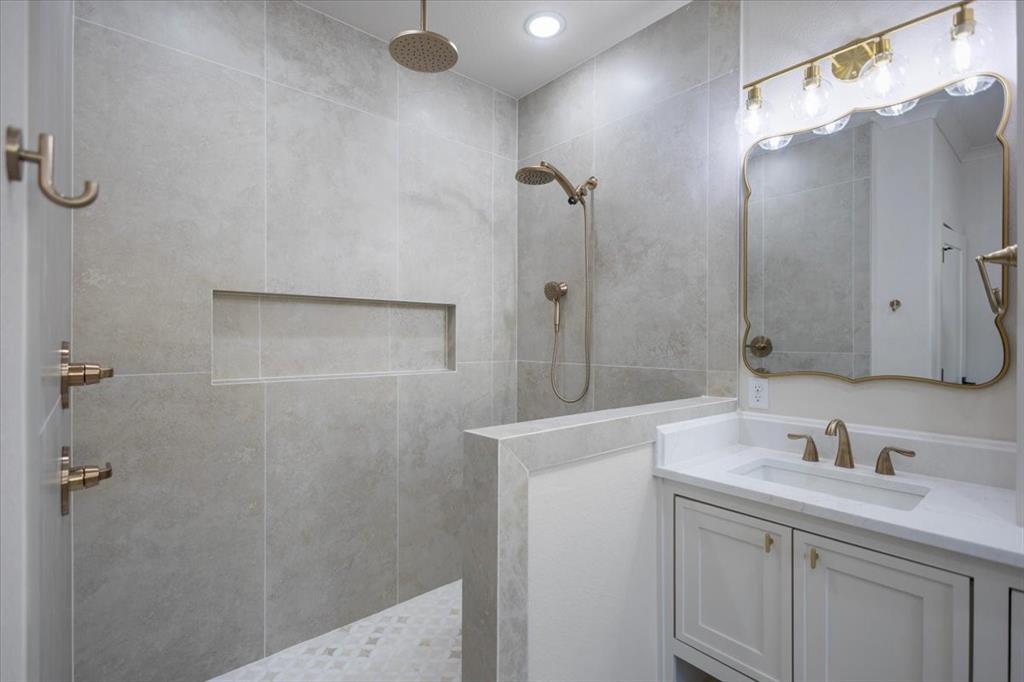 Walk-in shower with a rain shower head, handheld shower, and recessed niche