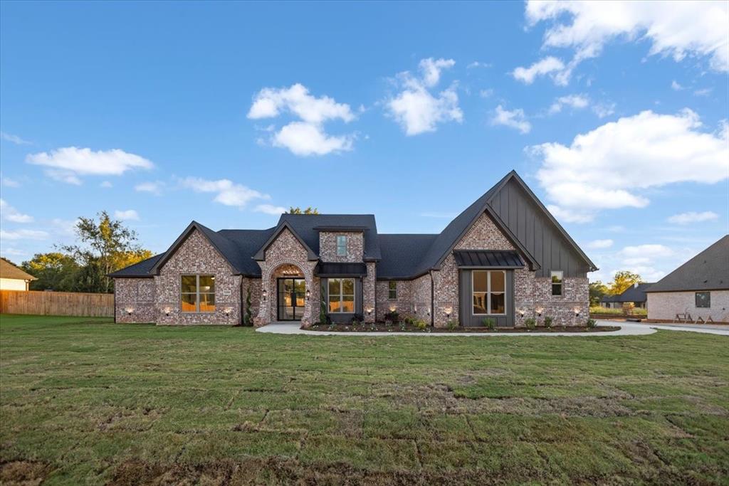 Brick and board-and-batten exterior with an arched entry