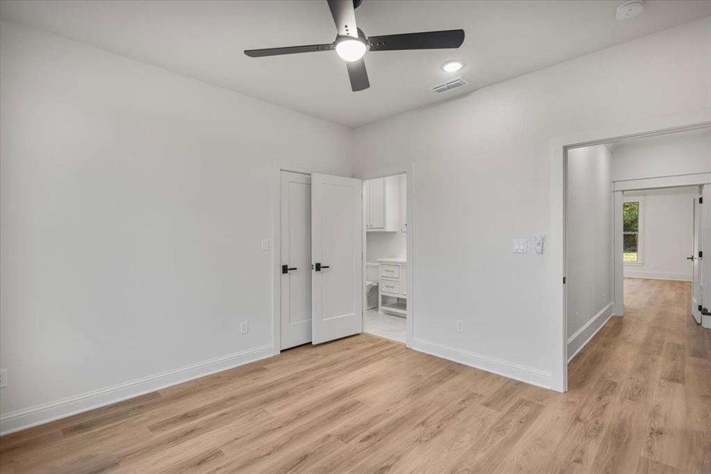 Wood-finish flooring, white walls, and a contemporary ceiling fan with integrated lighting