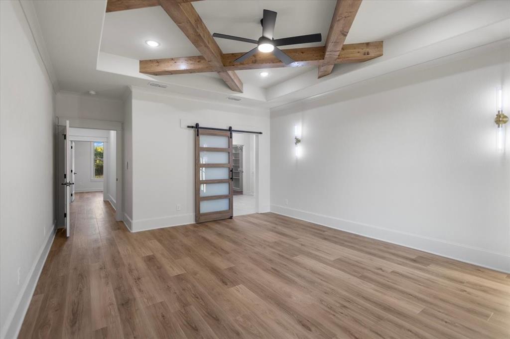 Tray ceiling with wood beam accents and recessed lighting