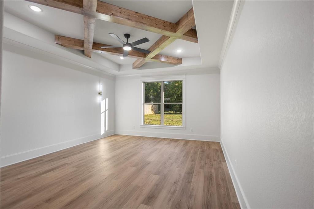 Tray ceiling with wood-finish beams, recessed lighting, and a ceiling fan