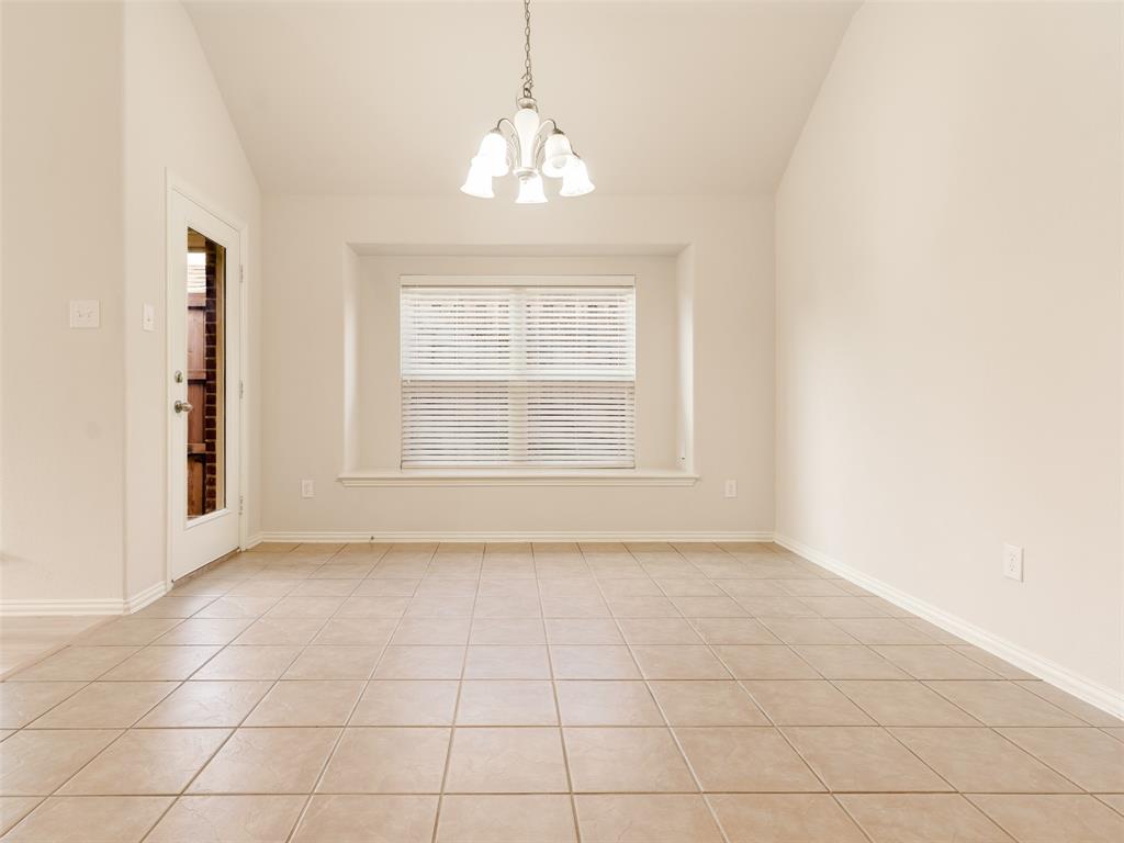 Vaulted ceilings, tile flooring, bay window, and a central multi-light pendant fixture