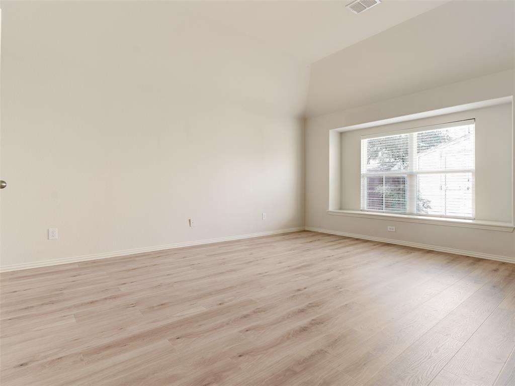 Vaulted ceilings, wood-finish flooring, and a recessed bay window