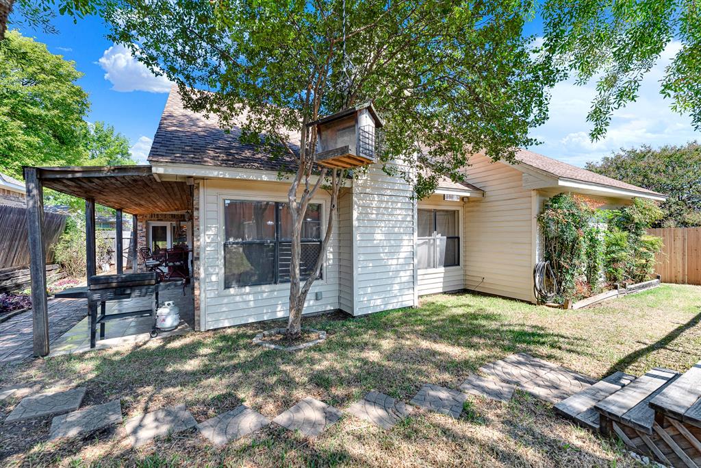 Stepping stones connect the covered porch to the shaded lawn and charming wooden birdfeeder. Start your mornings with a peaceful coffee break listening to songbirds in the quiet backyard.