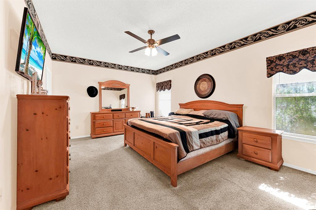 Soft natural light spills across the carpeted floor from dual windows, highlighting the room's generous proportions and clean ceiling lines. It provides a quiet, secluded haven where you can unwind and recharge at the end of a long day.