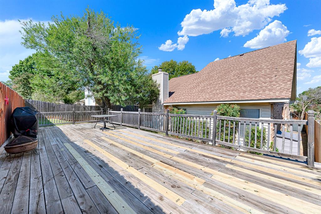 An expansive wooden deck provides an elevated vantage point surrounded by tree-canopied greenery. Picture setting up outdoor loungers for evening stargazing or hosting lively summer get-togethers.