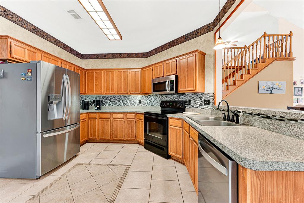 A wraparound layout with generous counter space, textured tile floors, and a glass tile backsplash keeps cooking effortless. Picture preparing weekend family breakfasts while easily chatting with guests at the pass-through bar. A wraparound layout with generous counter space, textured tile floors, and a glass tile backsplash keeps cooking effortless. Picture preparing weekend family breakfasts while easily chatting with guests at the pass-through bar.