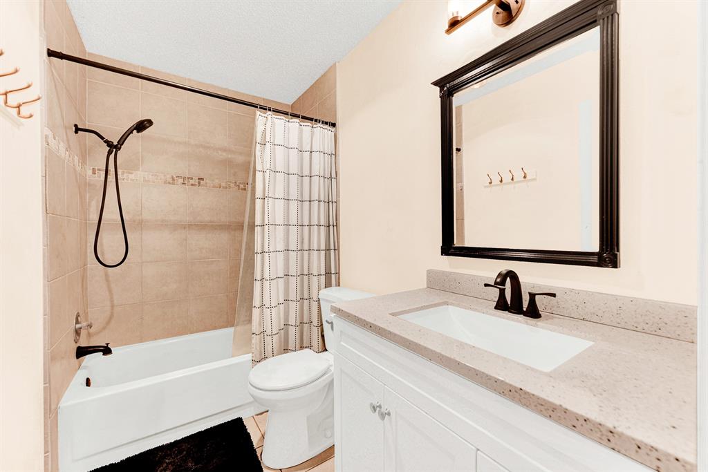 A crisp white vanity paired with oil-rubbed bronze fixtures and a tiled bath surround creates a clean, refreshed aesthetic. Visitors will appreciate having a dedicated, stylish space to prepare for the day in total comfort.