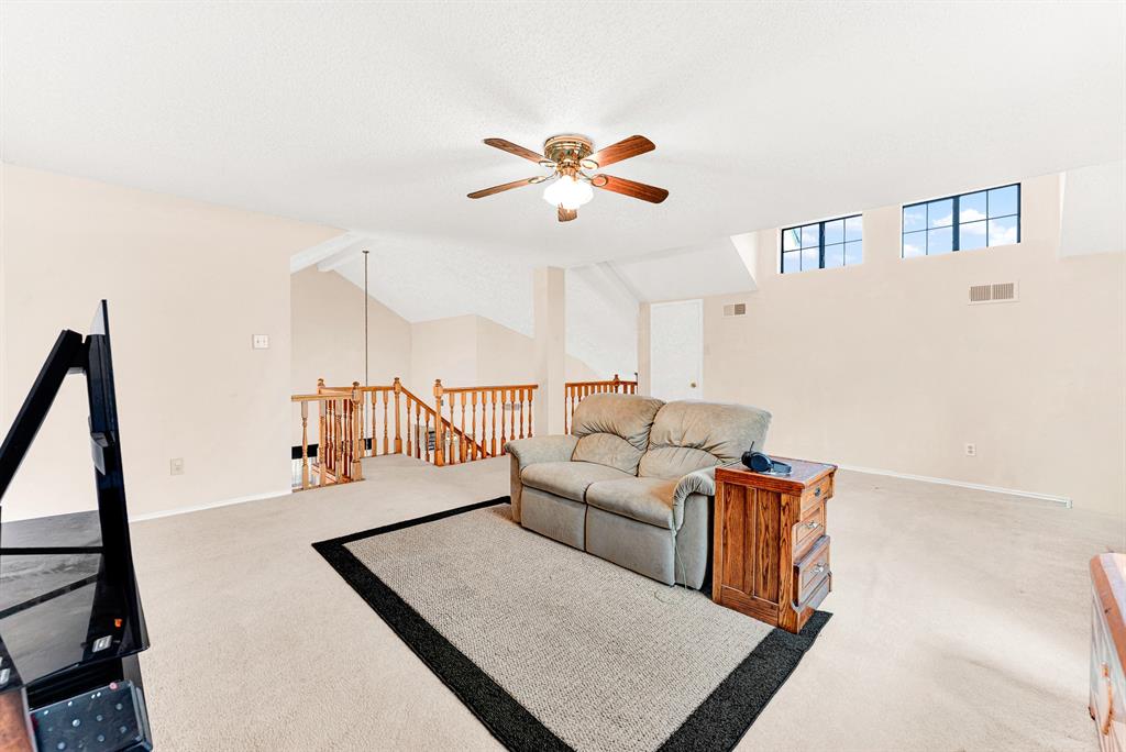 Architectural dormer-style upper windows bring soft natural light from above across the generous, carpeted flex room. You will love spending casual weekend afternoons lounging in this versatile secondary living retreat.
