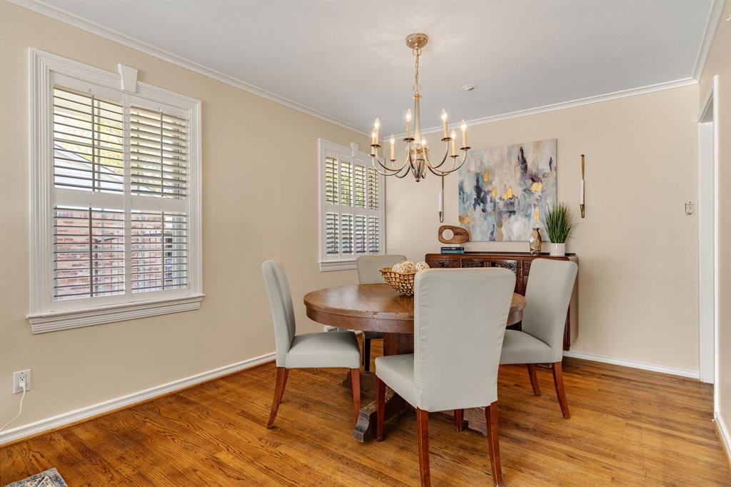 A lovely formal dining room with a classic chandelier and beautiful window trim and plantation shutters.  The dining area could easily accommodate a longer rectangular table as well.