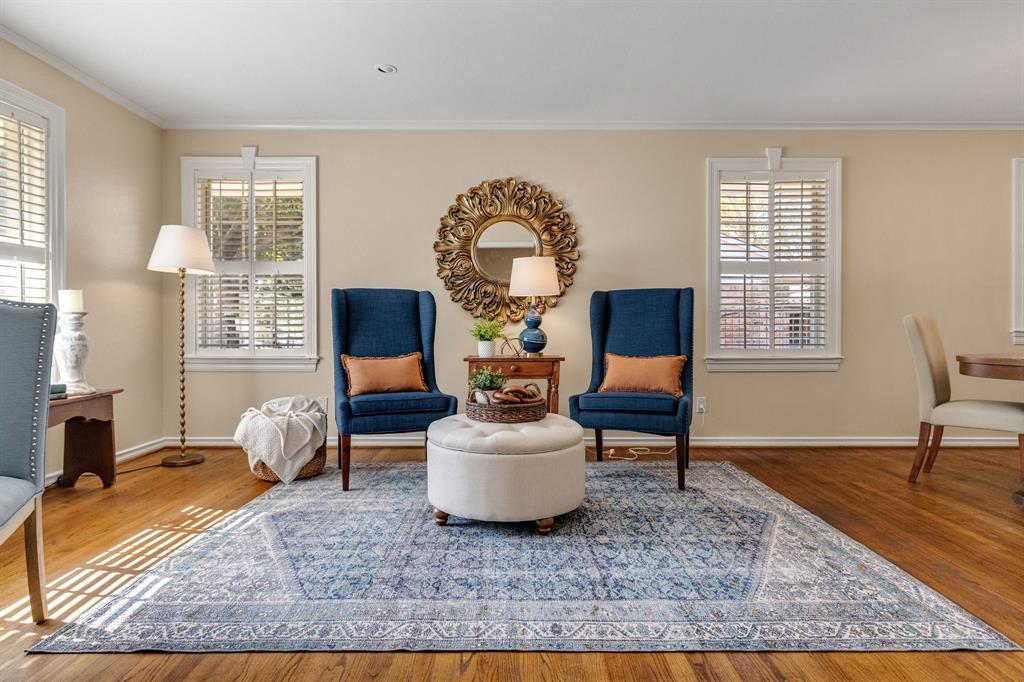 A beautiful room with custom window trim, plantation shutters, wood floors and tons of natural light.