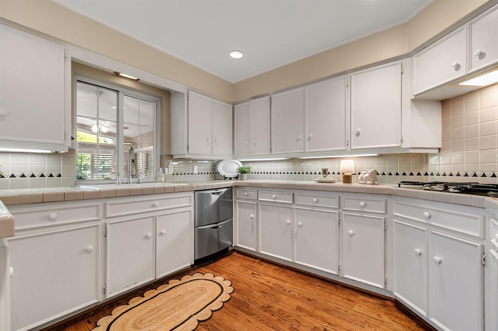 Lots of counters pace and cabinetry to work with in this kitchen!  Notice the drawer style stainless steel dishwasher and the wood floors that continue.
