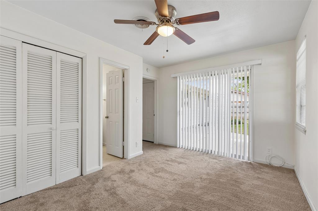 Primary bedroom with sliding glass doors leading to the backyard patio