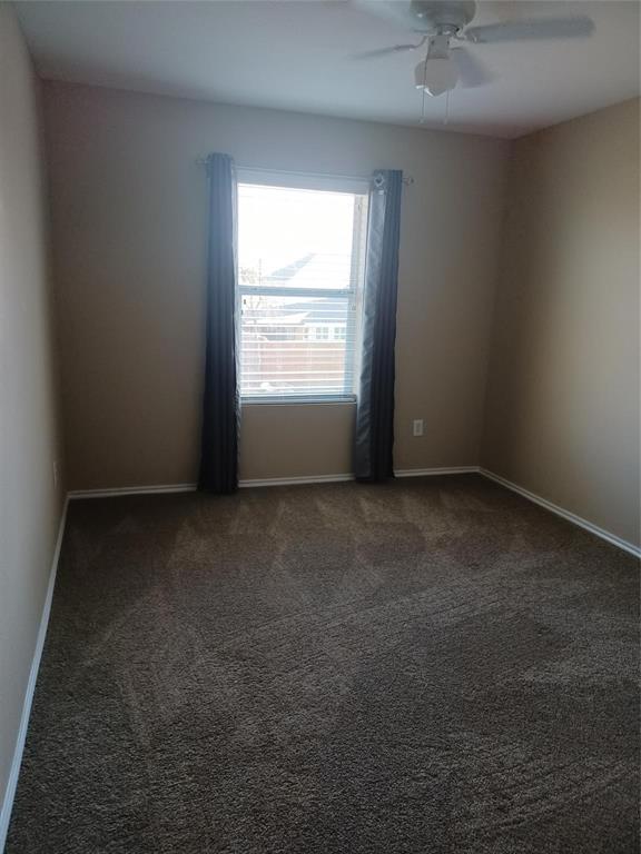 Carpeted room with a ceiling fan, a window with blinds, and neutral tone walls