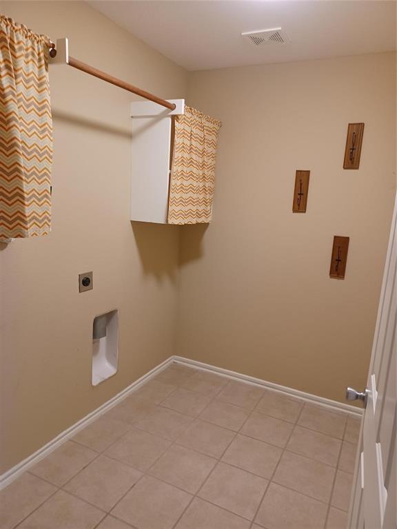 Tile flooring, wall-mounted cabinetry, and a ceiling-mounted light fixture