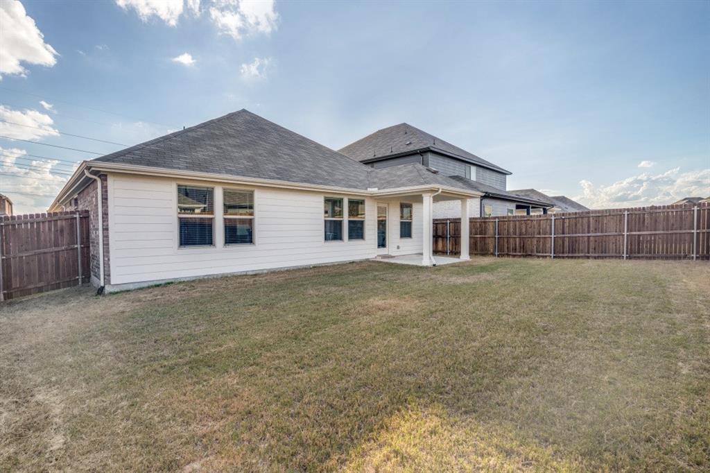 Rear exterior featuring a covered patio, horizontal siding, shingle roof, and a fenced backyard