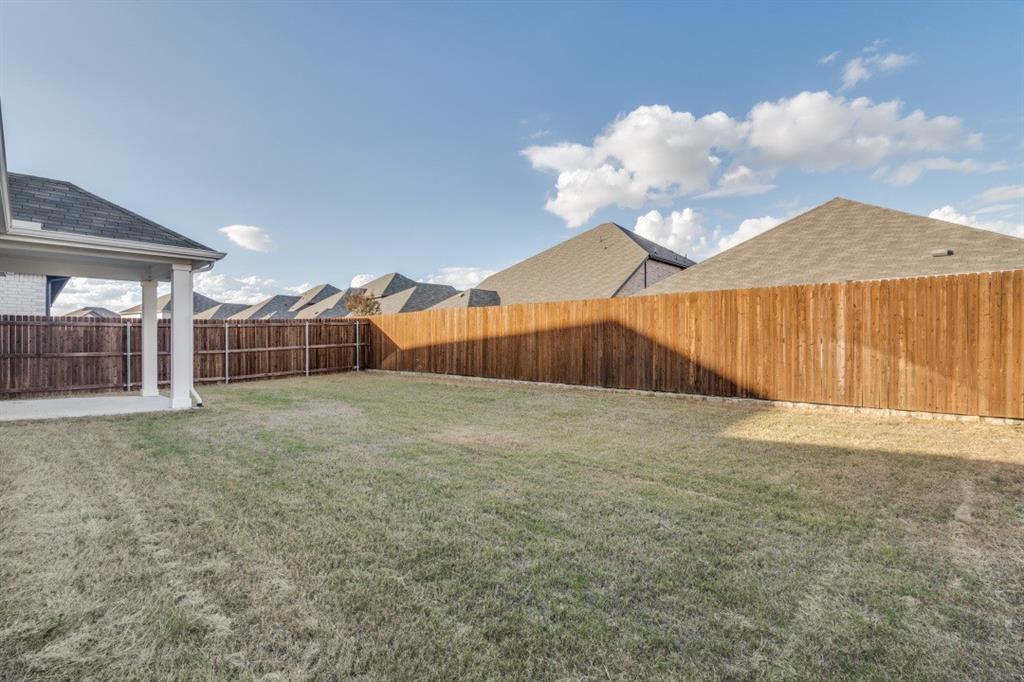 Backyard featuring a concrete patio, covered porch area with square columns, and wooden privacy fencing