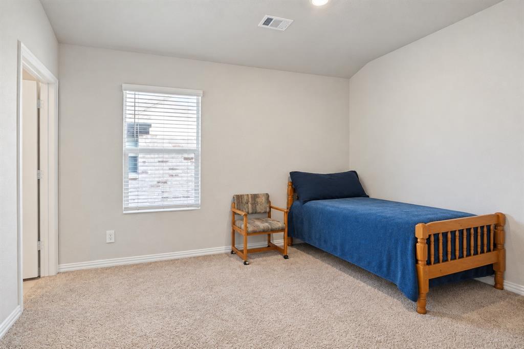 Neutral-toned interior space featuring wall-to-wall carpeting and a single-hung window with horizontal blinds