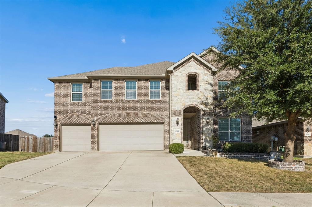 Brick and stone facade, arched entryway, two-car garage, concrete driveway, and mature landscaping Brick and stone facade, arched entryway, two-car garage, concrete driveway, and mature landscaping