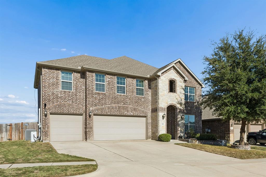 Two-story brick exterior with stone accents, arched entry, two-car garage, and established front landscaping Two-story brick exterior with stone accents, arched entry, two-car garage, and established front landscaping