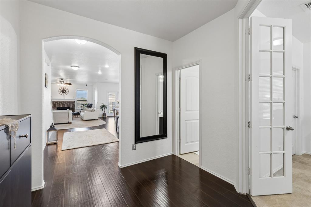 Dark wood-finish flooring extending through an arched entryway Dark wood-finish flooring extending through an arched entryway