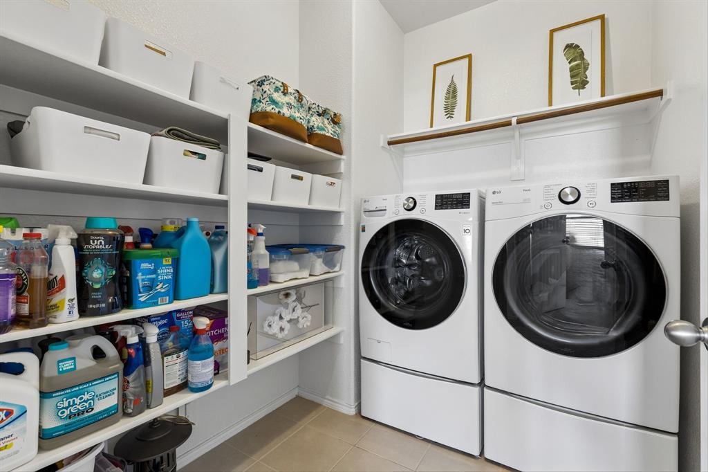 Laundry area with built-in shelving, white front-loading appliances, and a hanging rod