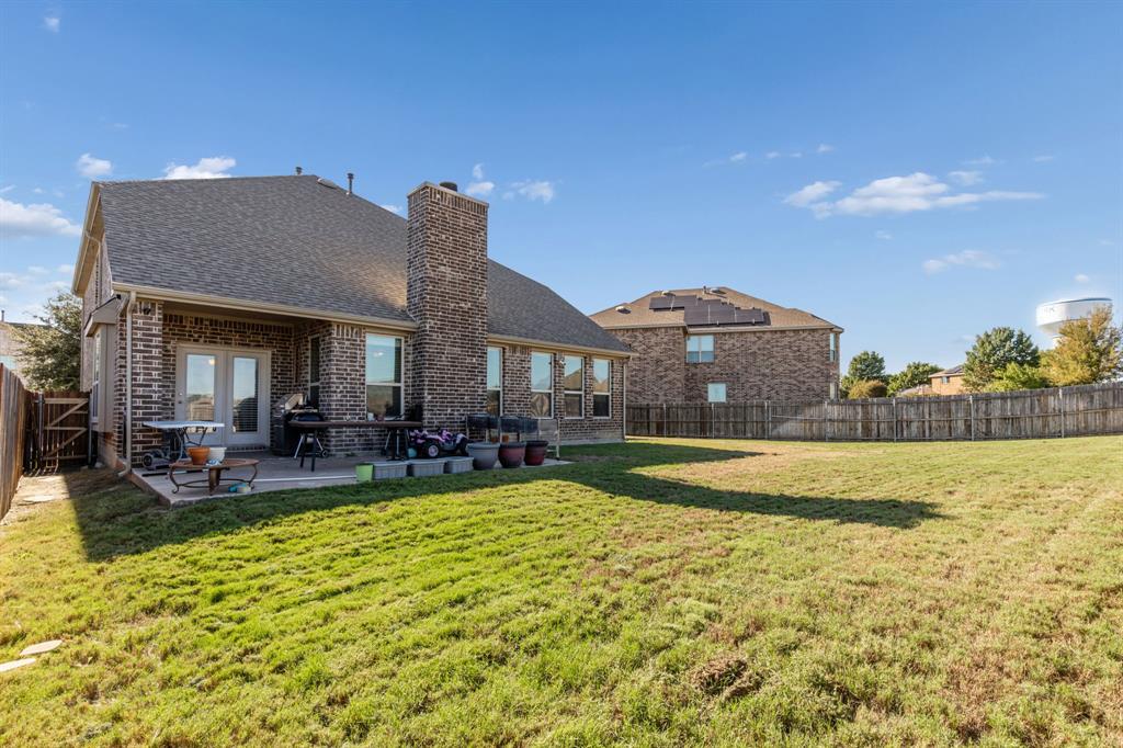 Brick exterior with a gabled roof and a concrete patio