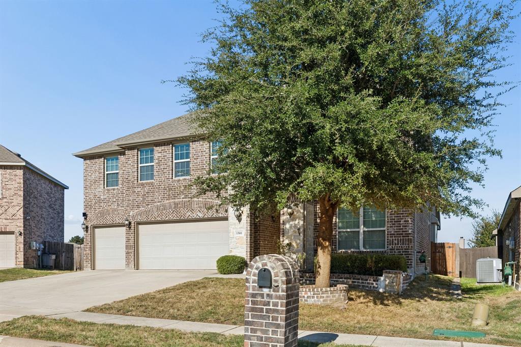 Two-story brick exterior with a two-car garage and arched garage door accents Two-story brick exterior with a two-car garage and arched garage door accents
